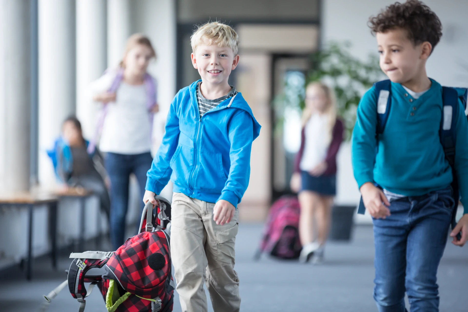Børn i skoleindgang med rygsække, klar til skolestart.